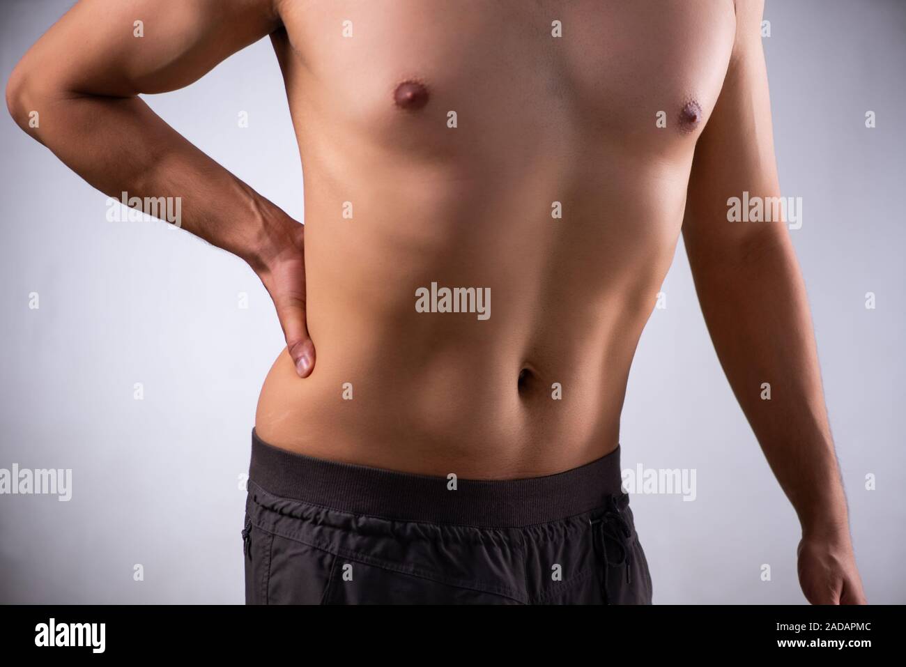 Man suffering from backbain on gray Stock Photo