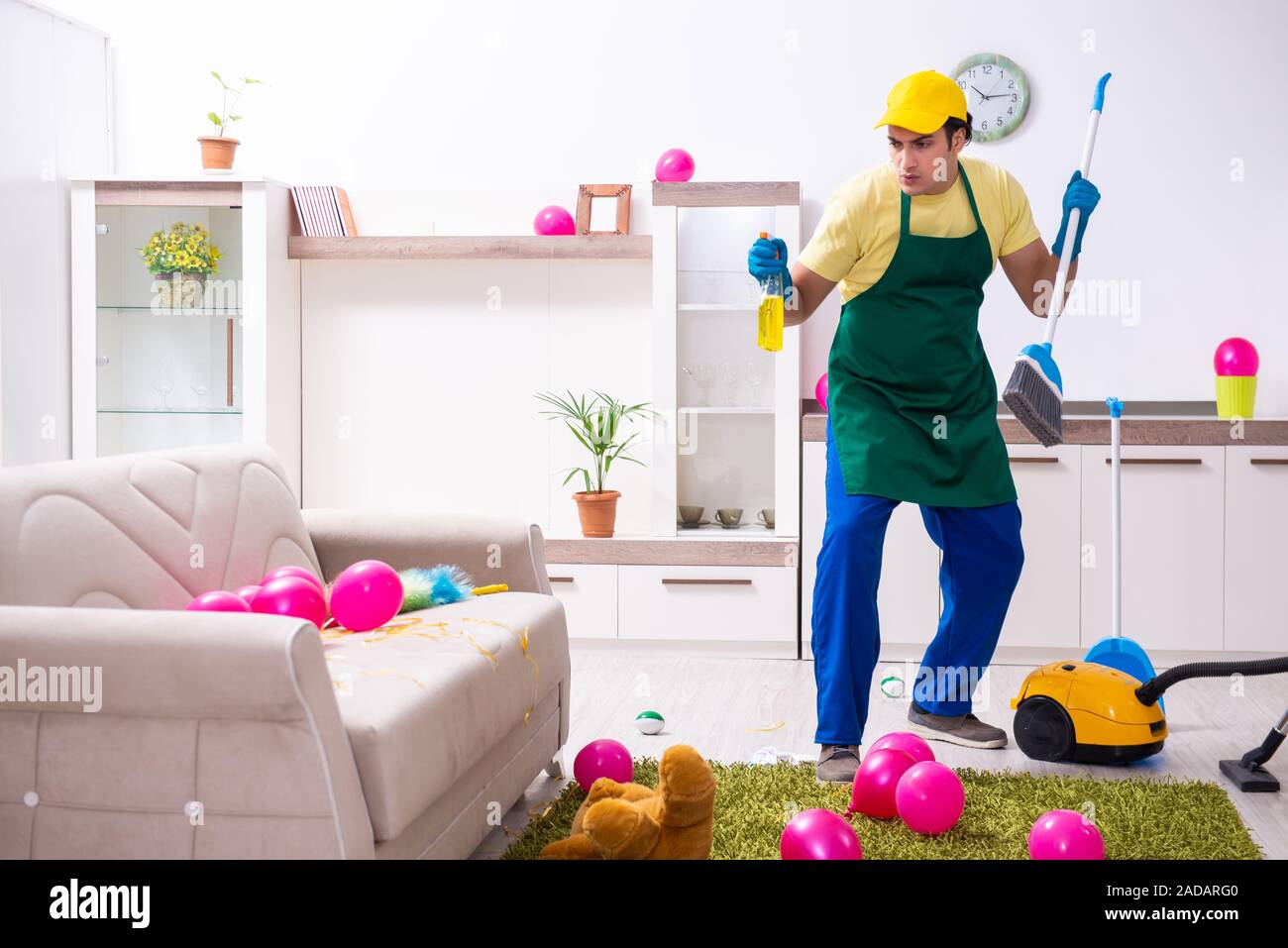 Young male contractor doing housework after party Stock Photo