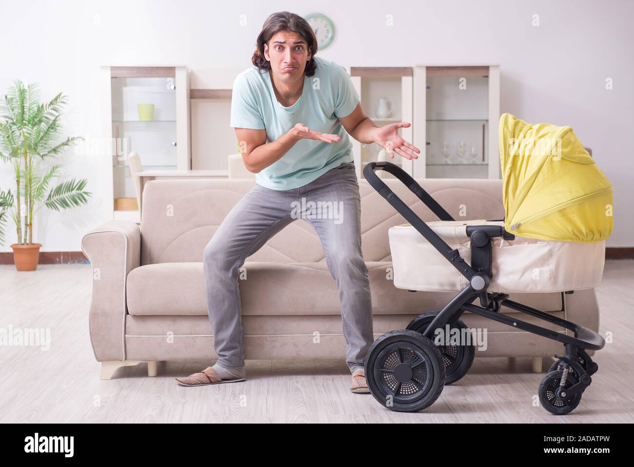 Young man looking after baby in pram Stock Photo