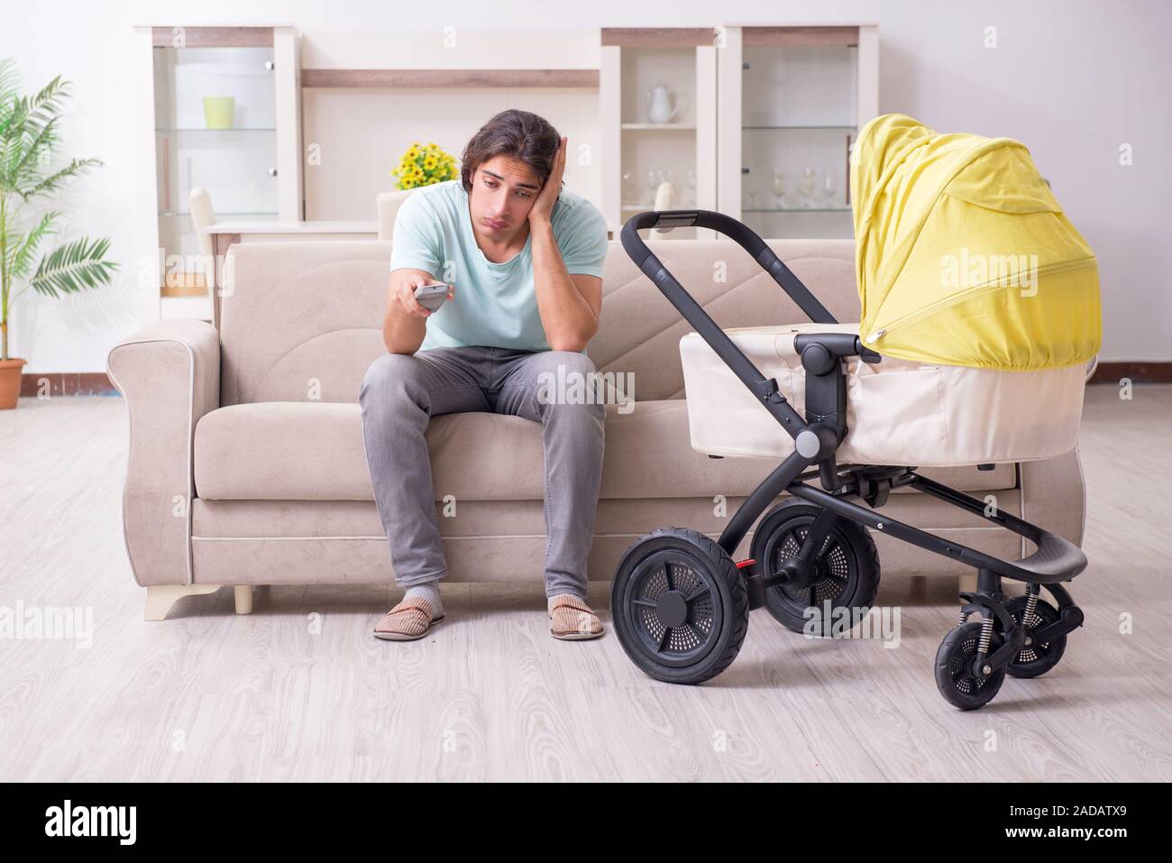 Young man looking after baby in pram Stock Photo