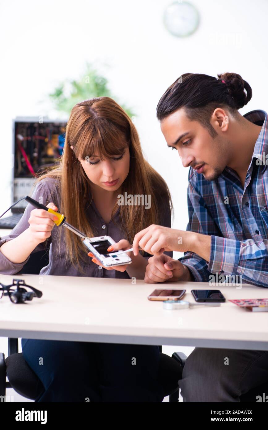 Two technicians working at computer warranty center Stock Photo