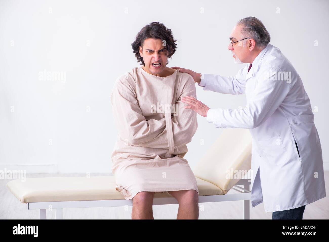 Aged male doctor psychiatrist examining young patient Stock Photo Alamy