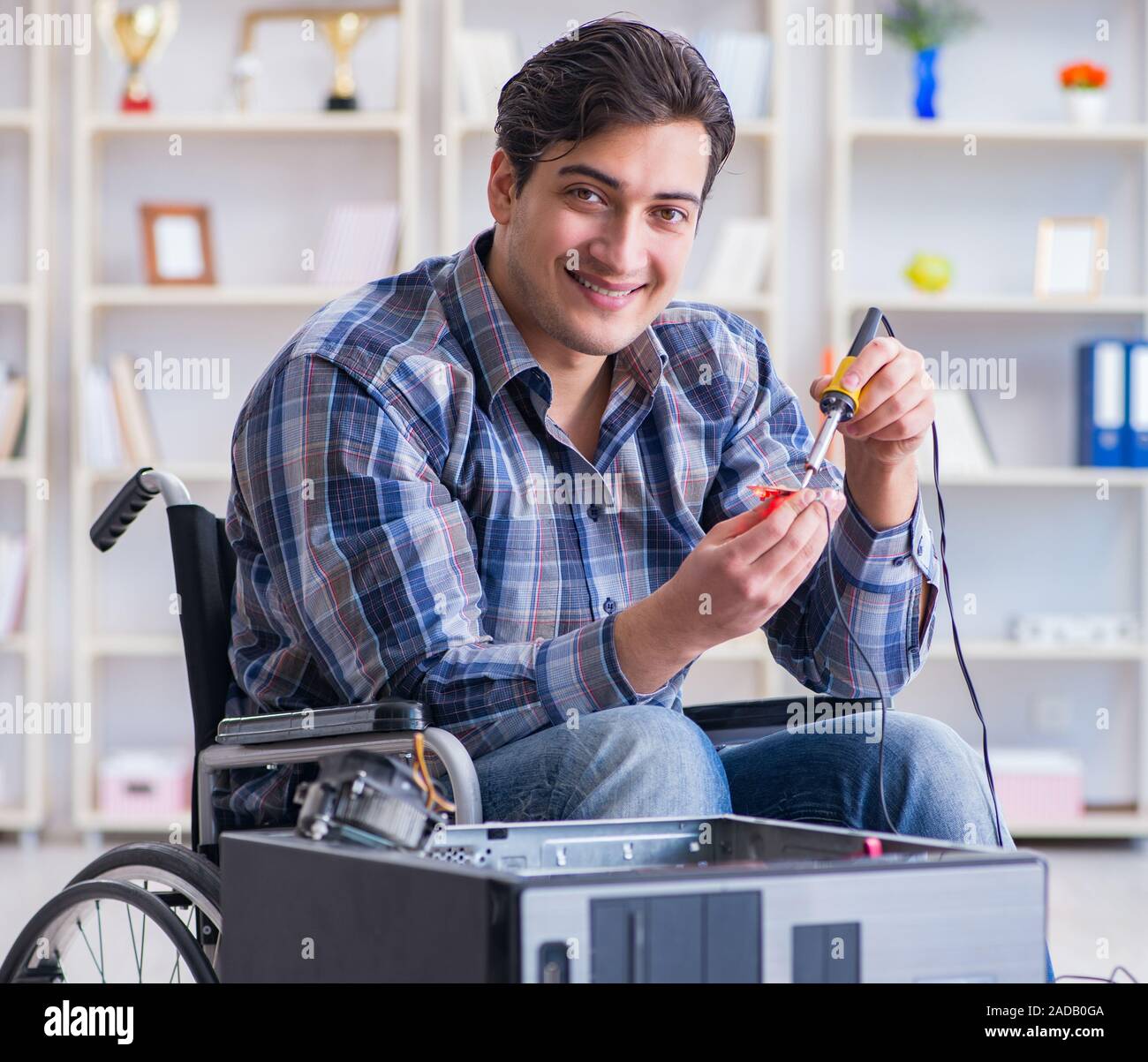 Computer repairman on wheelchair working Stock Photo