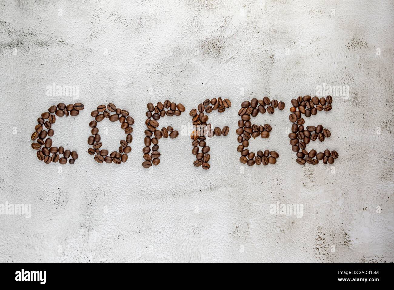 Light textured background image with coffee word written with coffee beans Stock Photo