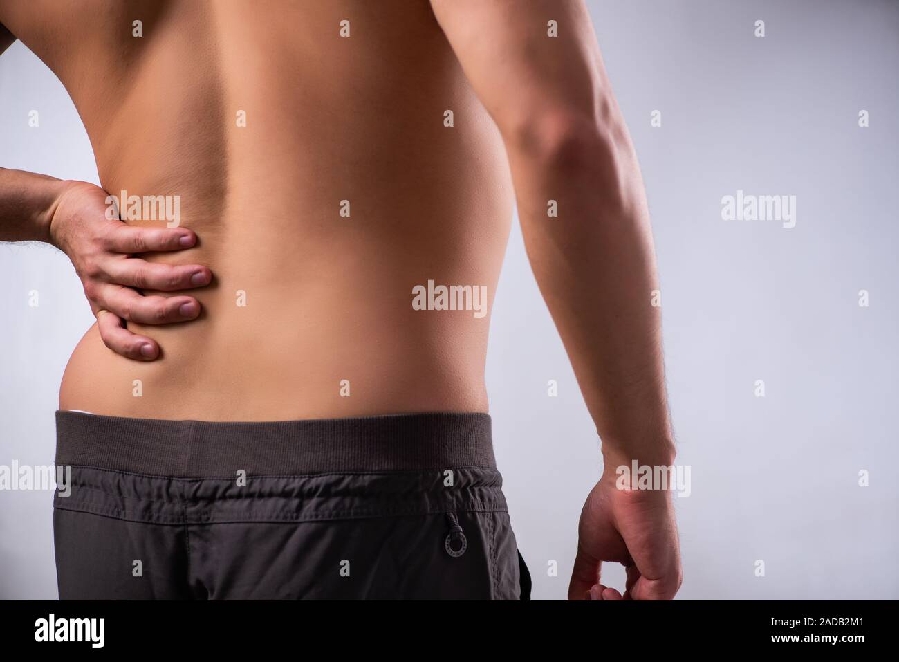 Man suffering from backbain on gray Stock Photo
