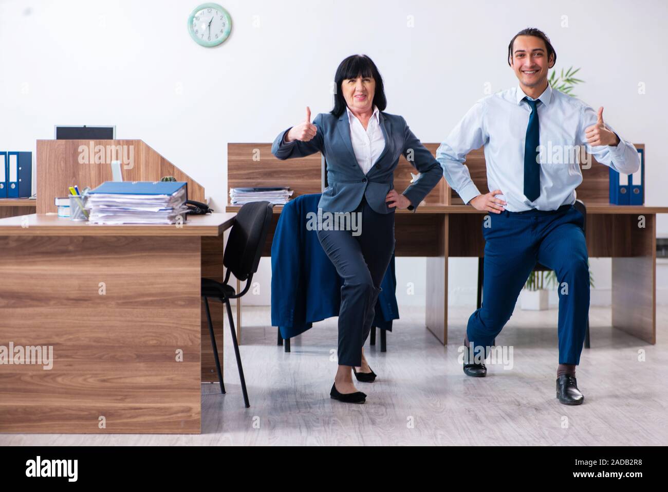 Two employees doing sport exercises in the office Stock Photo