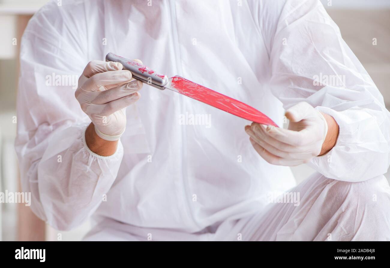 Forensic expert at crime scene doing investigation Stock Photo