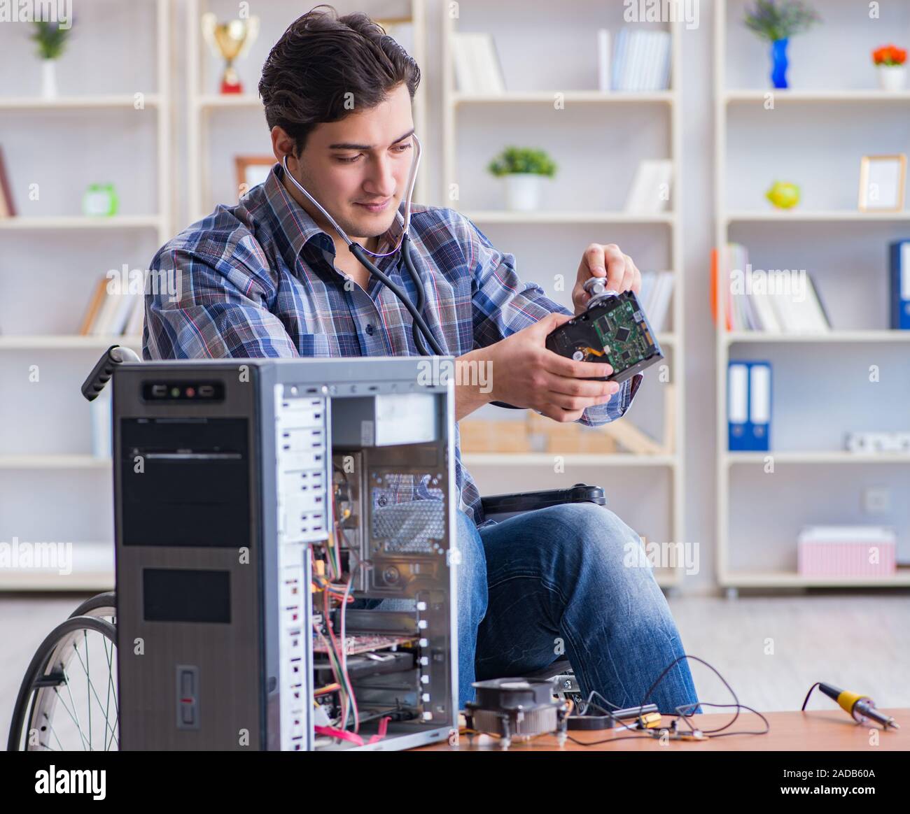 Computer repairman on wheelchair working Stock Photo