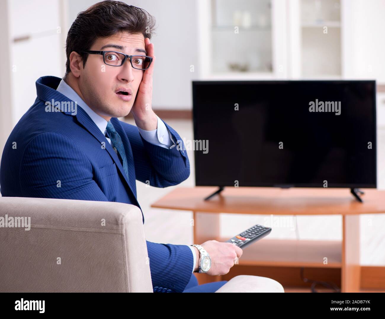 Businessman watching tv in the office Stock Photo Alamy