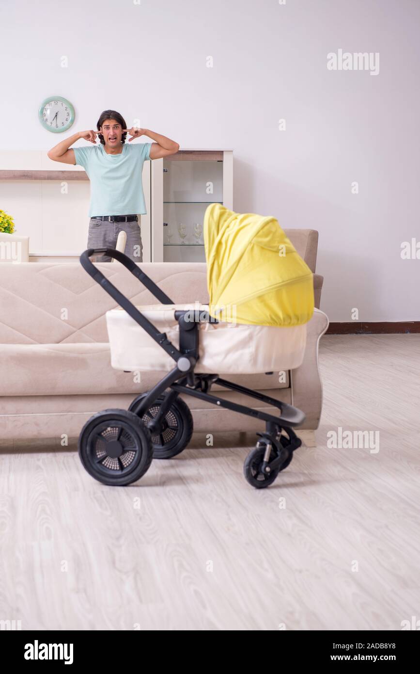 Young man looking after baby in pram Stock Photo Alamy