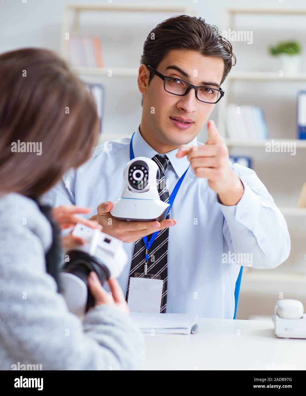 Sales assistant showing cameras to client in shop Stock Photo