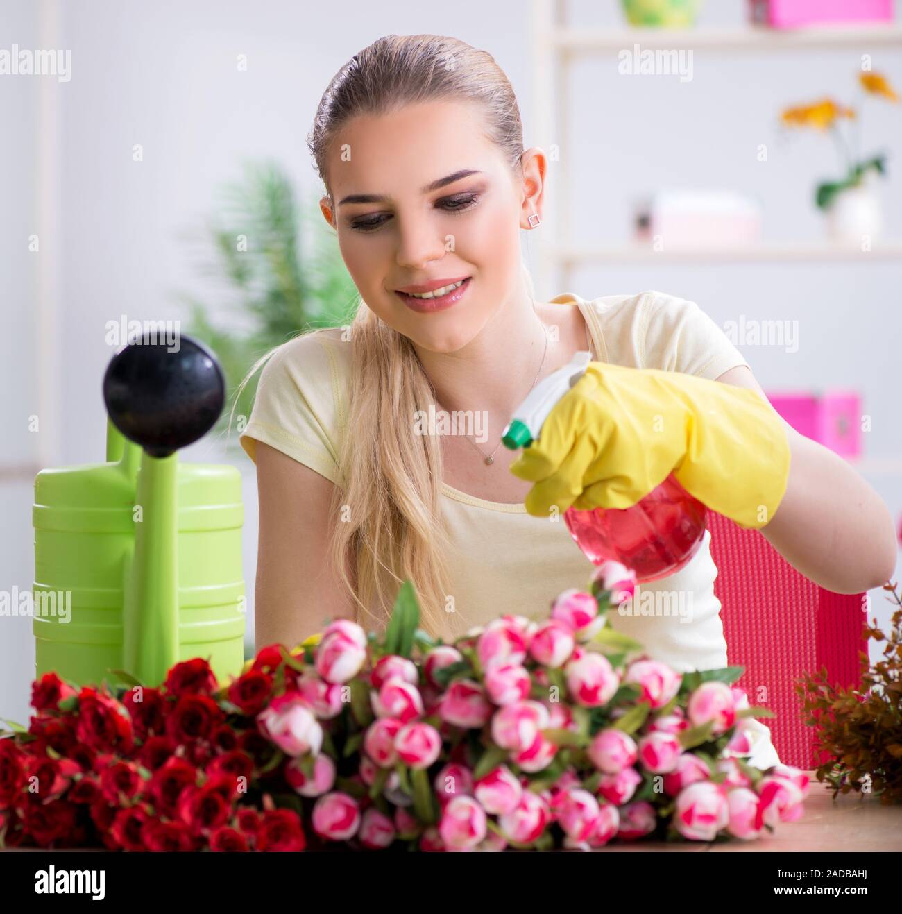 Young woman watering plants in her garden Stock Photo - Alamy