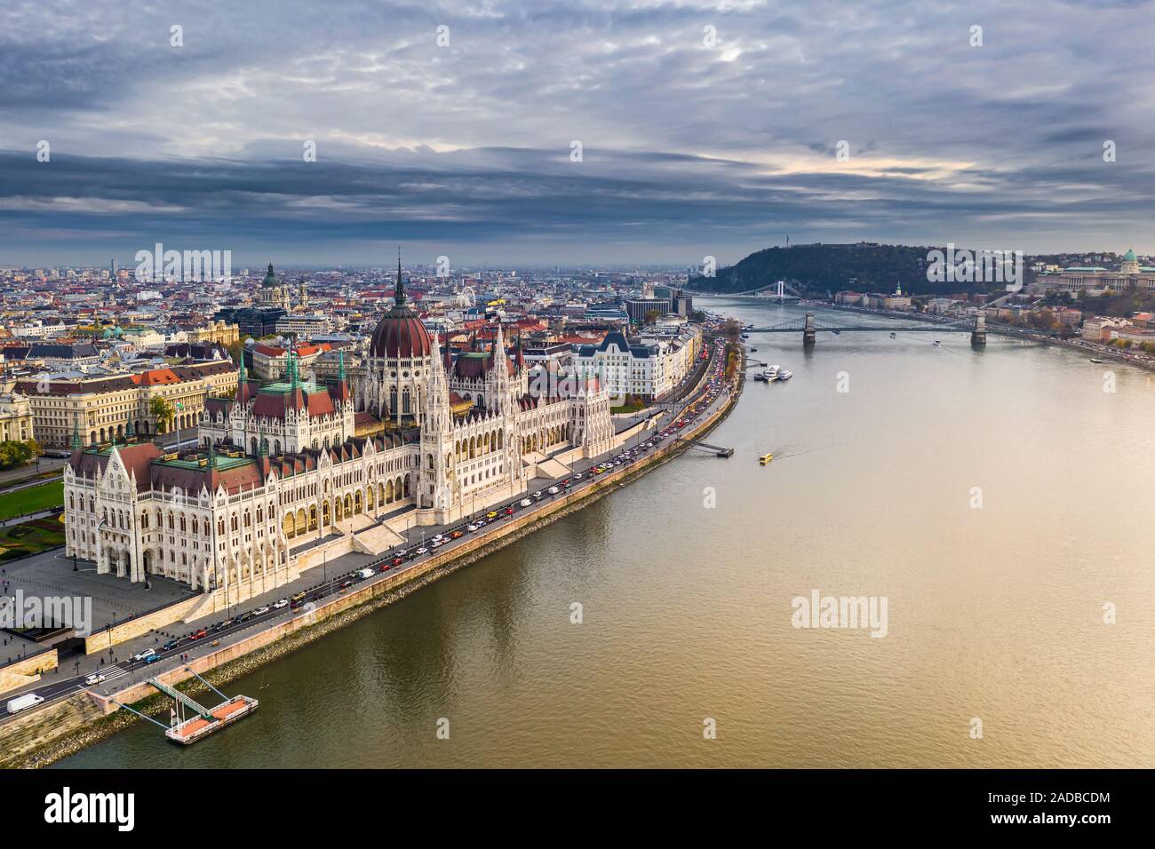 Budapest, Hungary - Aerial view of the beautiful Parliament of Hungary at sunset with golden lights and sightseeing boats on River Danube. Szechenyi C Stock Photo