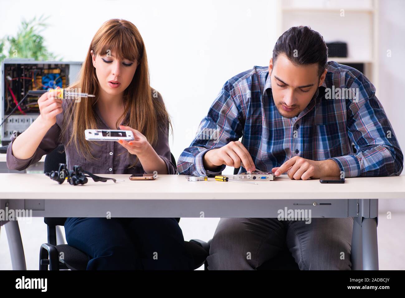 Two technicians working at computer warranty center Stock Photo