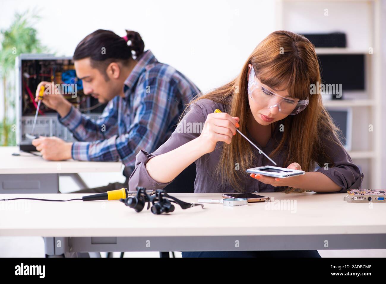 Two technicians working at computer warranty center Stock Photo