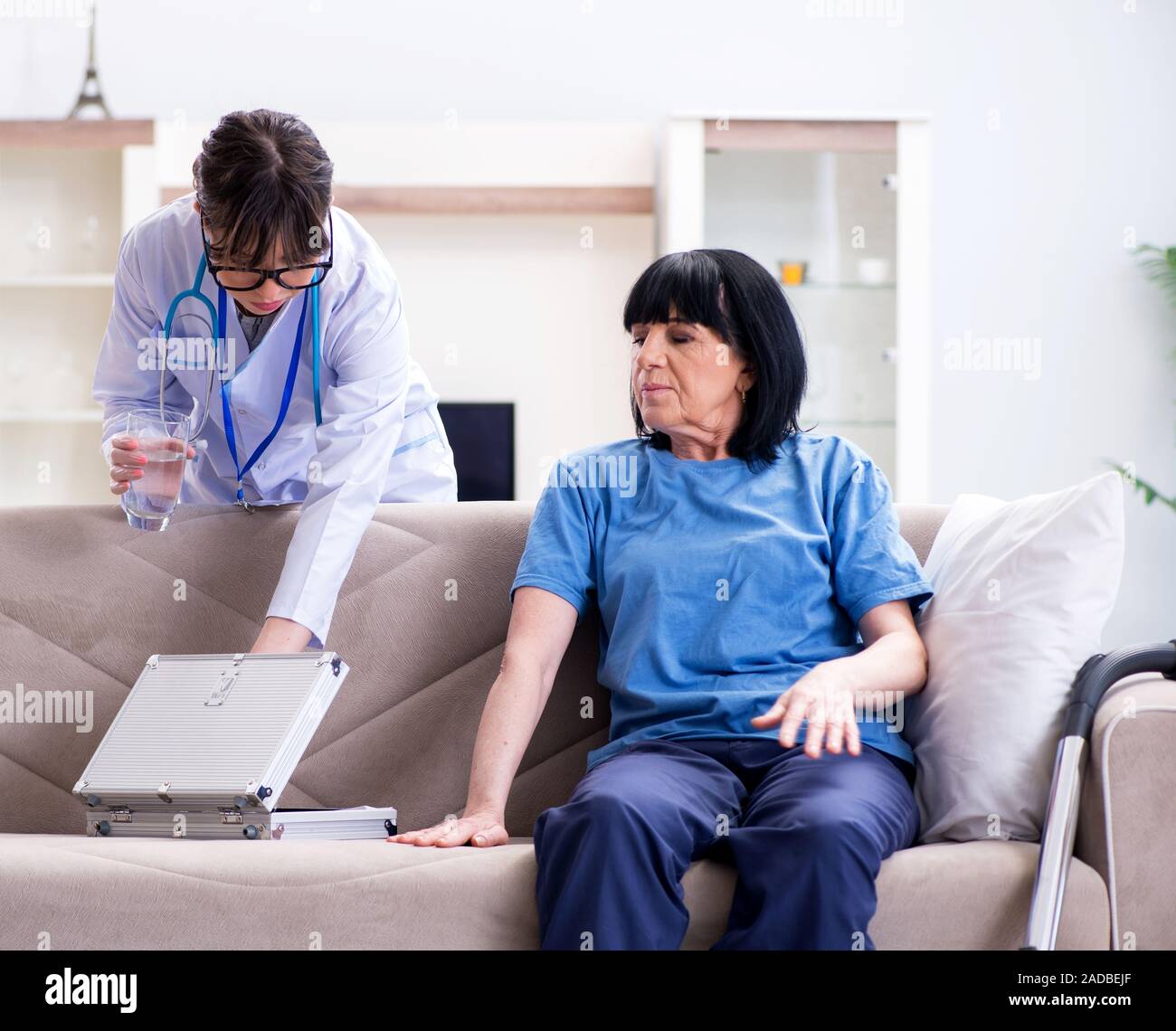 Young Doctor Visiting Old Mature Woman For Check Up Stock Photo