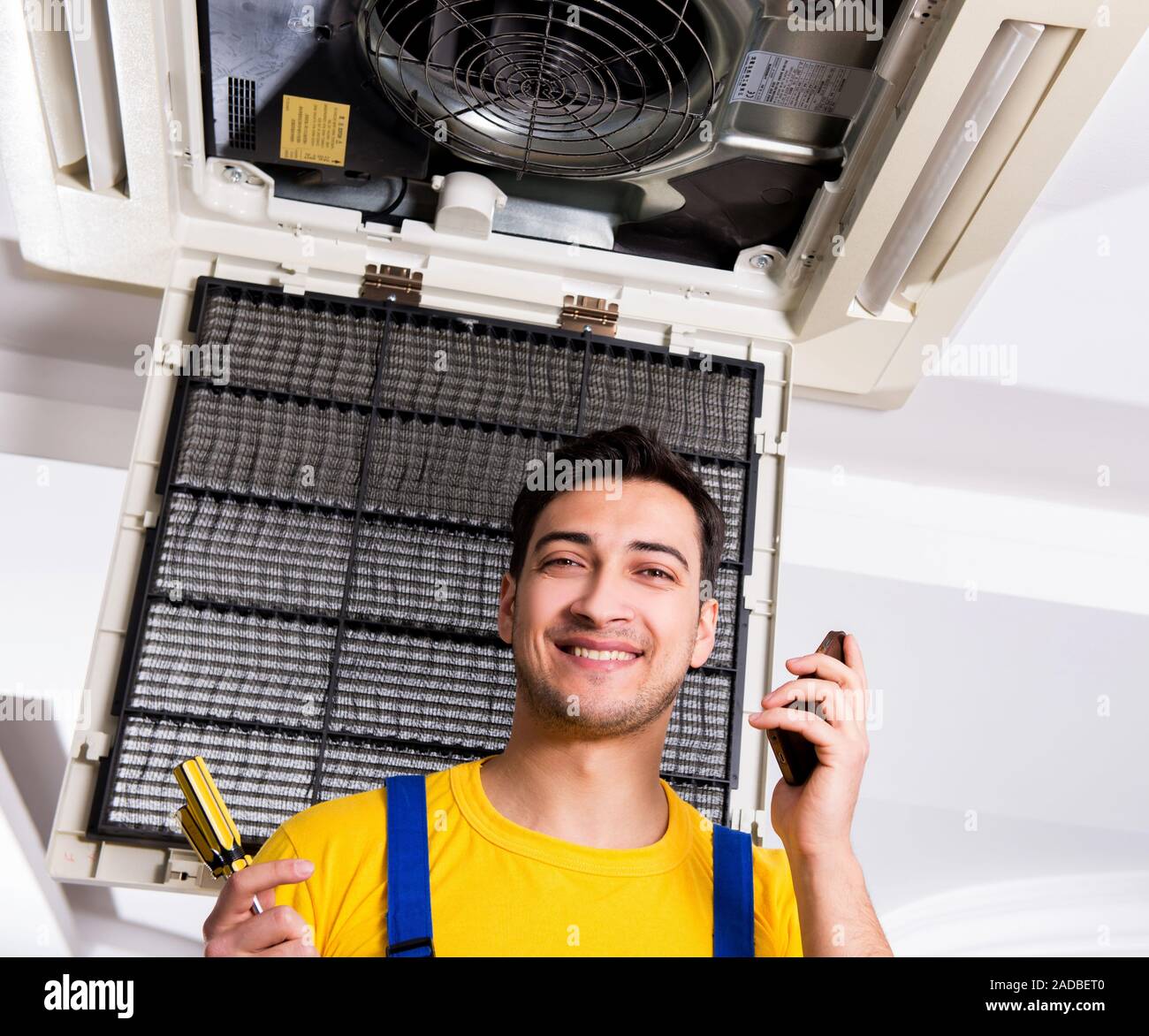Repairman repairing ceiling air conditioning unit Stock Photo Alamy
