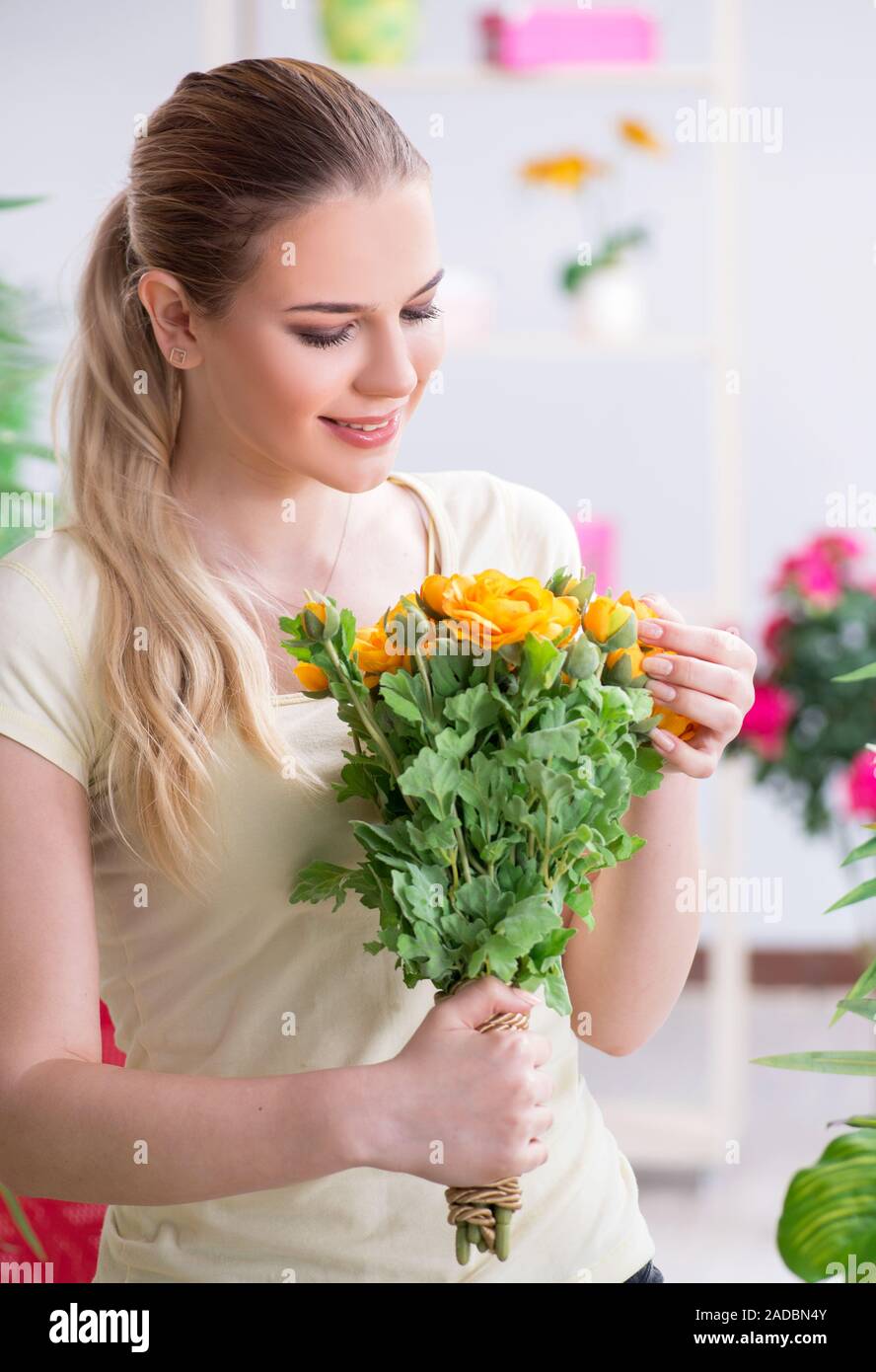 Young woman watering plants in her garden Stock Photo - Alamy