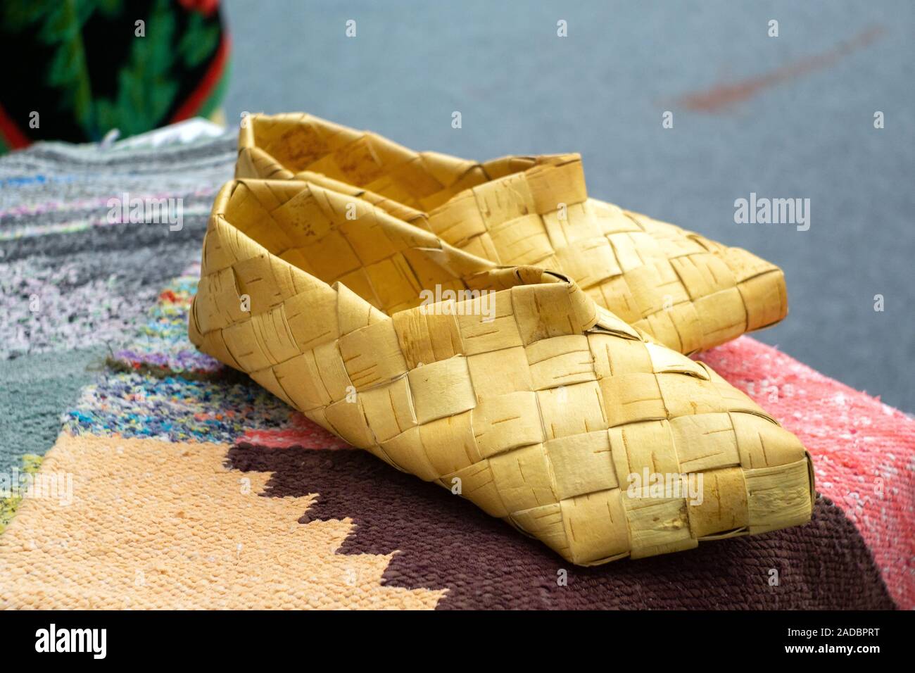Old Russian sandals made of bark. Birch bark shoes, traditional old Russian  shoes lie on an old traditional carpet in the sun Stock Photo - Alamy