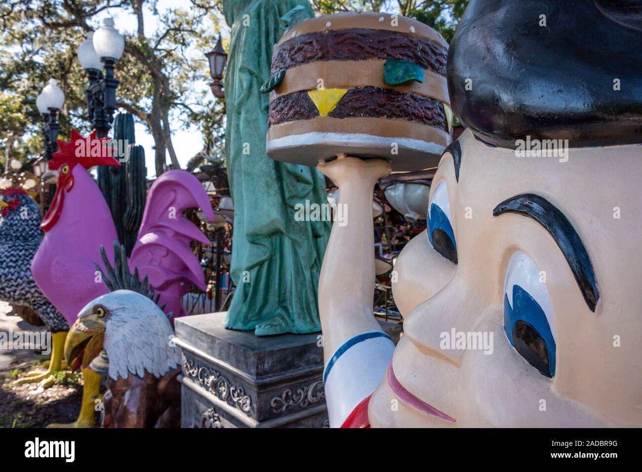 Shoney's Big Boy stands alongside the Statue of Liberty and various large painted metal statues at Barberville Yard Art Emporium in Pierson, Florida. Stock Photo