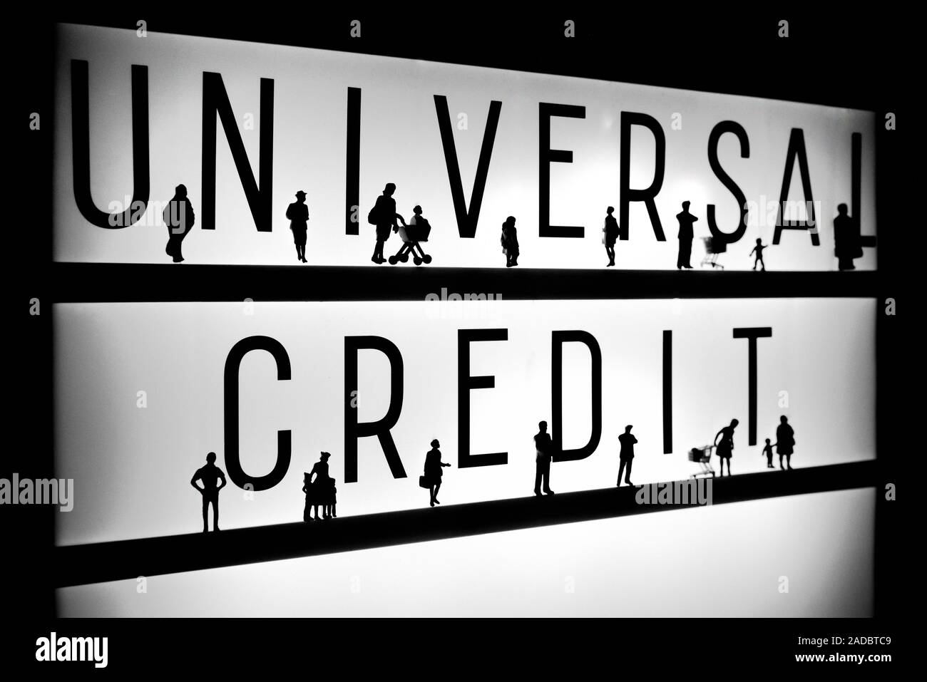 Miniature figurines standing in front of the words universal credit concept Stock Photo