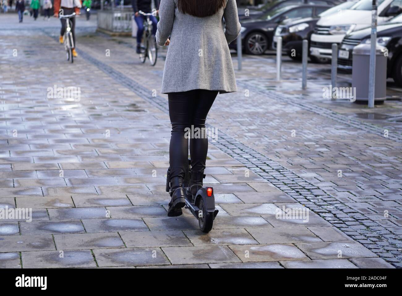electric scooter or e-scooter on busy city sidewalk shared with bicycles and pedestrians Stock Photo