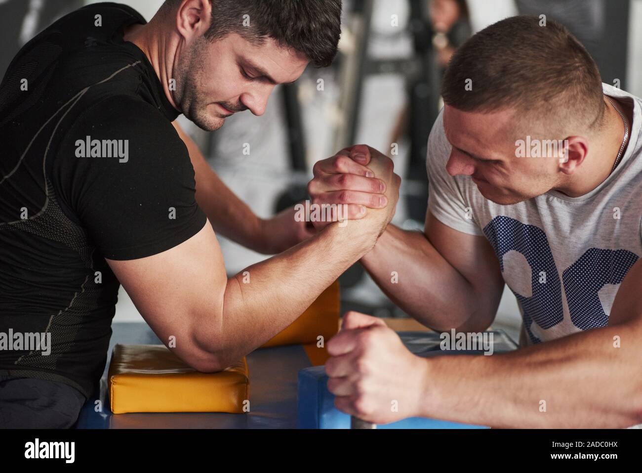 Tense atmosphere. Arm wrestling challenge between two men. Match on a special table Stock Photo