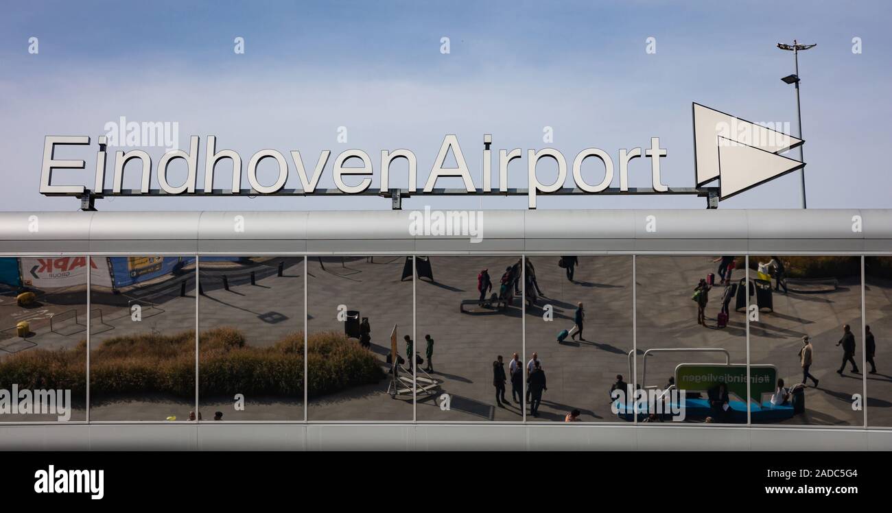 Eindhoven Netherlands. October 14, 2019. Eindhoven airport text sign at terminal facade, sunny autumn day. People reflecting on the glass Stock Photo