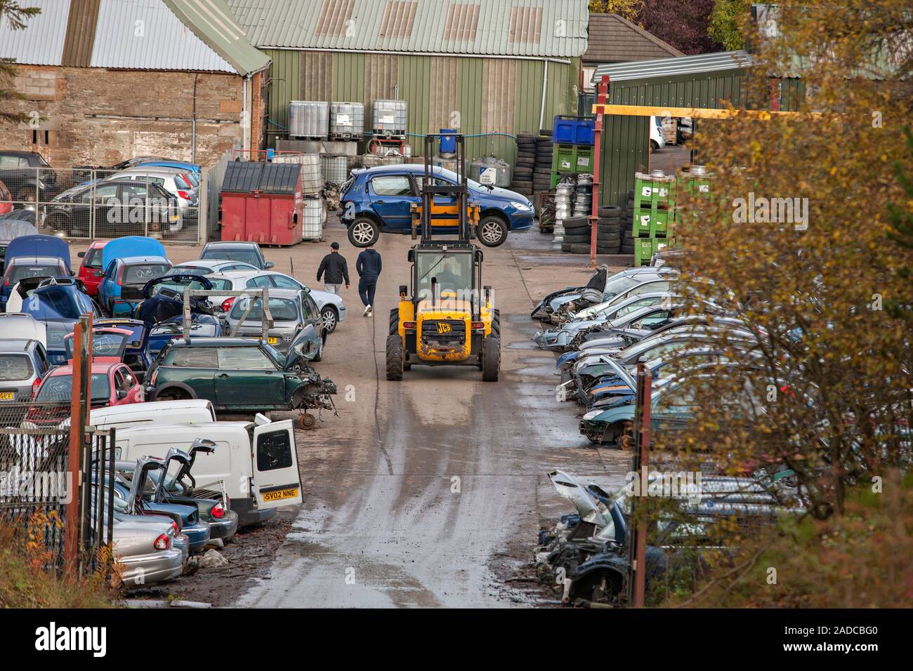 Scrapyard. Car being moved by a forklift at a scrapyard. Photographed