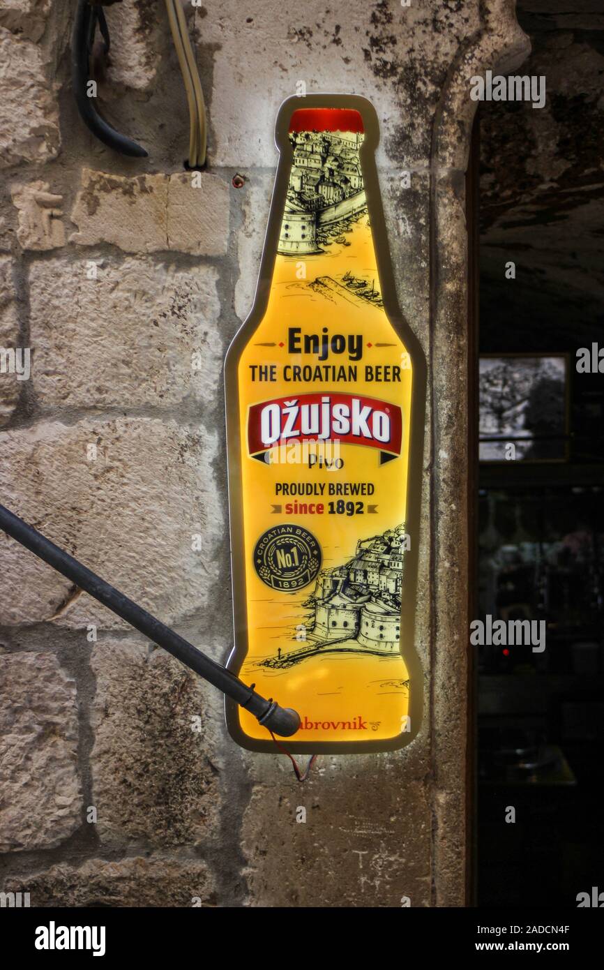 illuminated advertising sign of Croatian Ožujsko beer next to bar entrance in Old Town Dubrovnik, Croatia Stock Photo