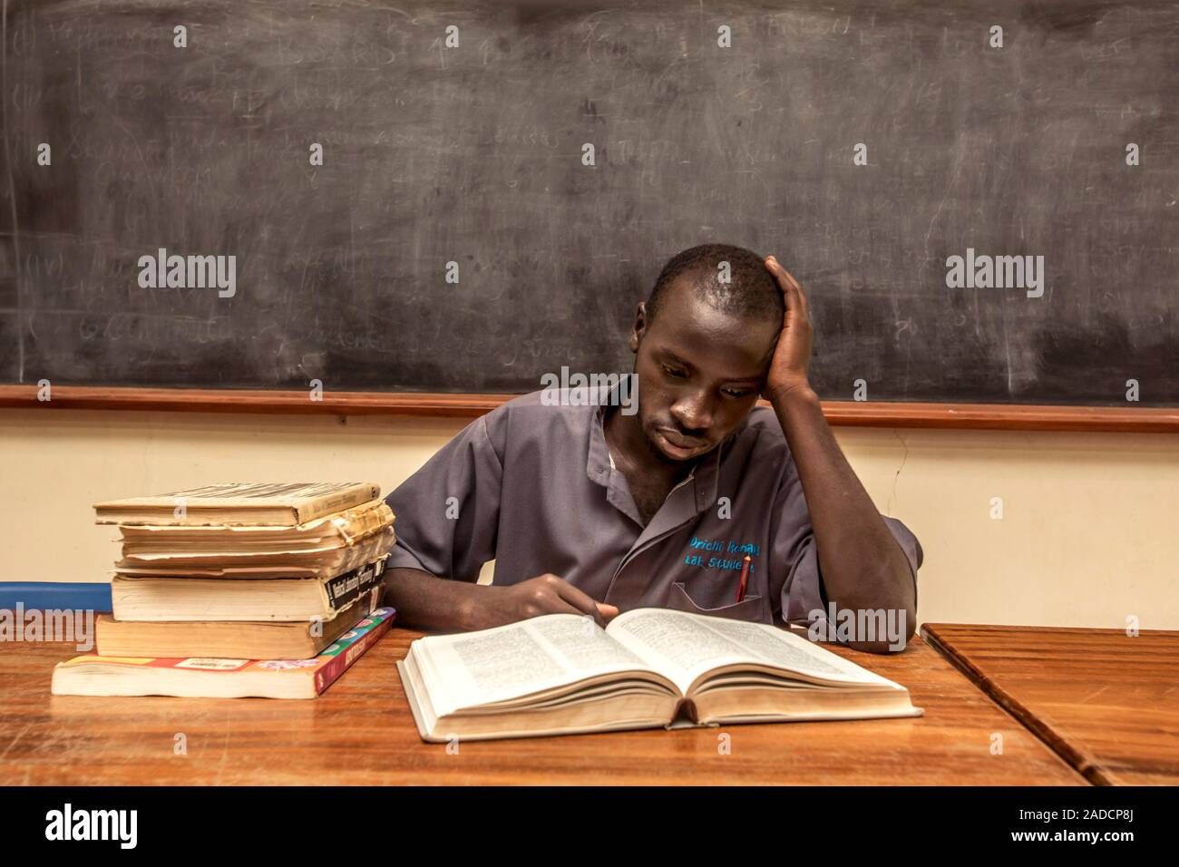 Medical student studying in a classroom in front of a blackboard