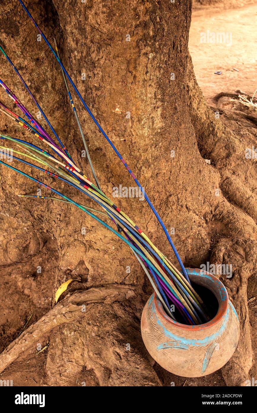 Traditional objects in a clay pot by a tree. Photographed in a rural