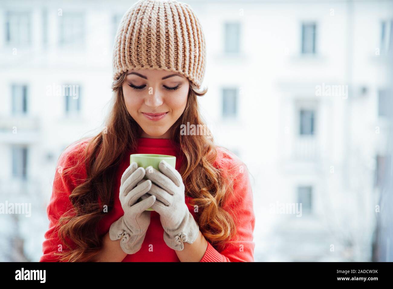 the girl in the hat froze and drinking hot tea Stock Photo
