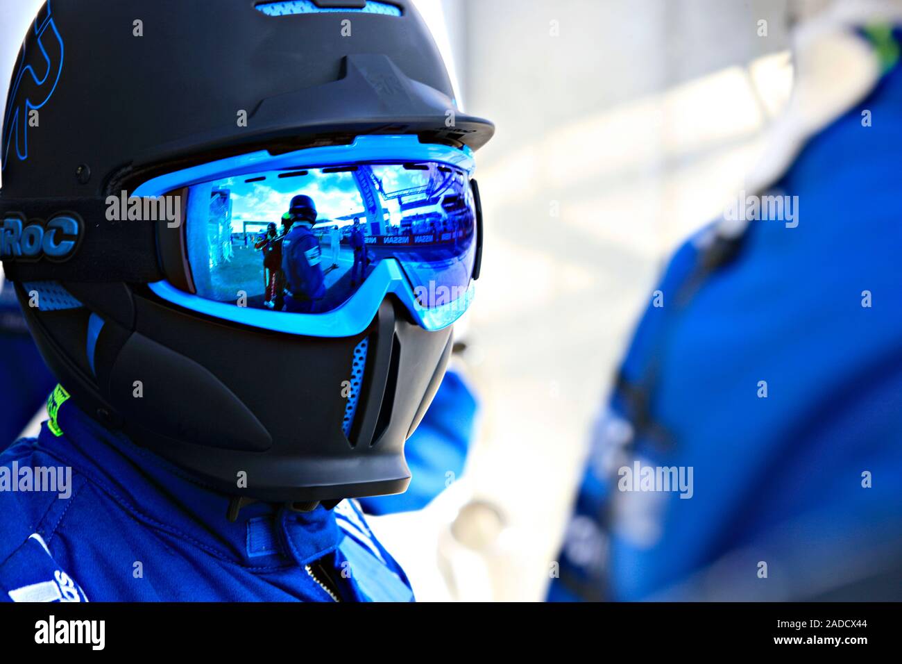 Racing car mechanic, wearing a safety helmet and goggles. This mechanic ...