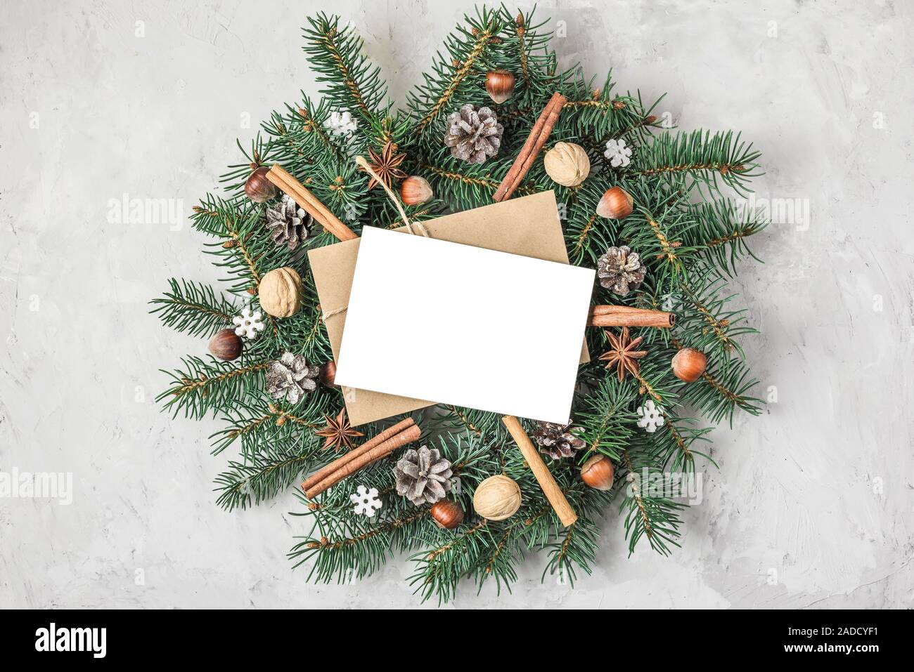 Christmas wreath made of natural fir tree and christmas food with greeting card on concrete background. Christmas, Happy New Year concept. top view. f Stock Photo