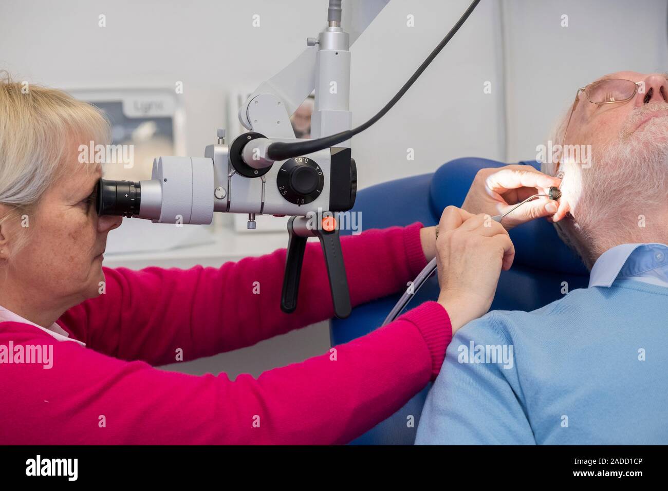 Ear wax removal clinic. Man having excess ear wax removed. Excessive