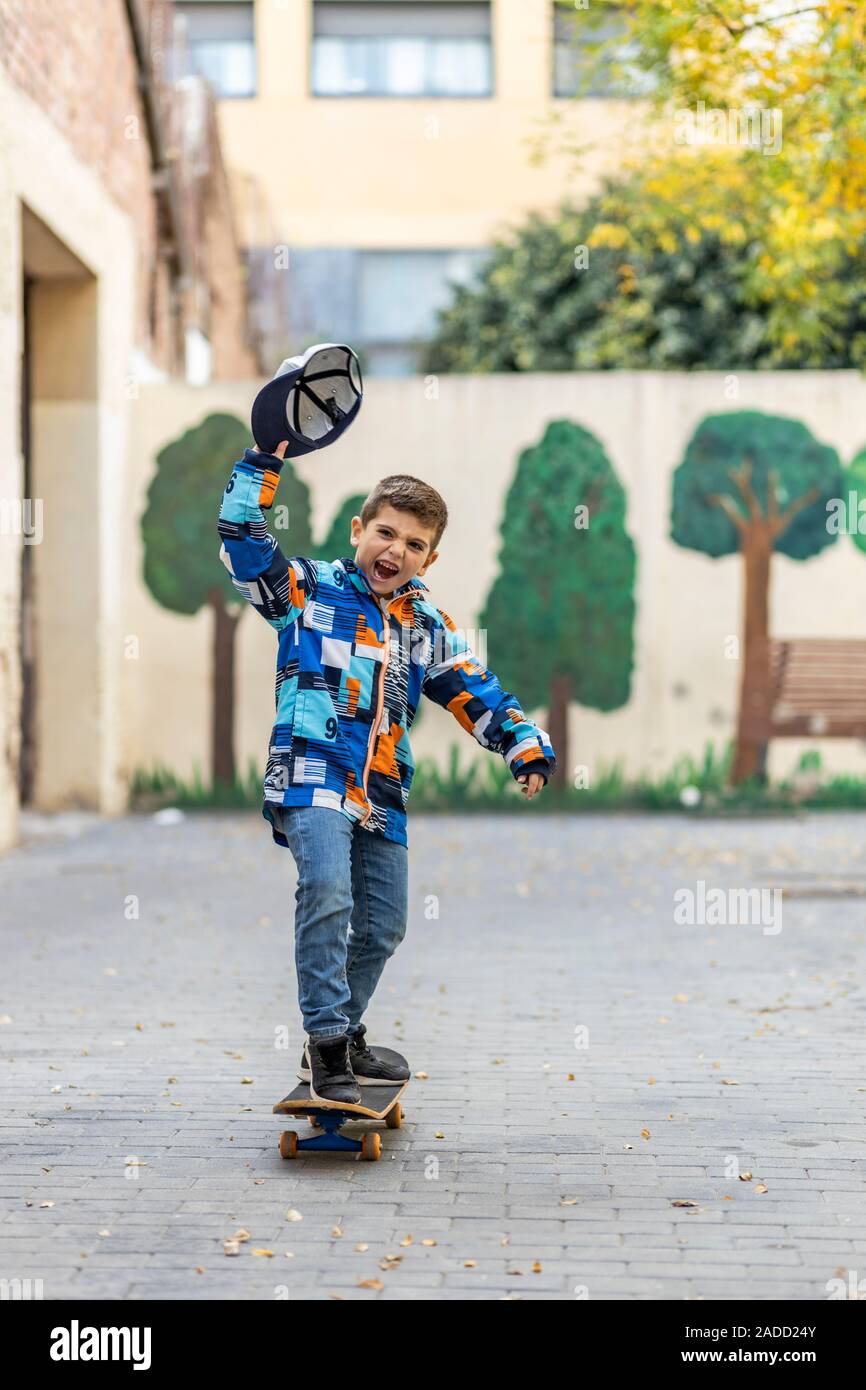 Euphoric little kid riding on his skateboard Stock Photo - Alamy