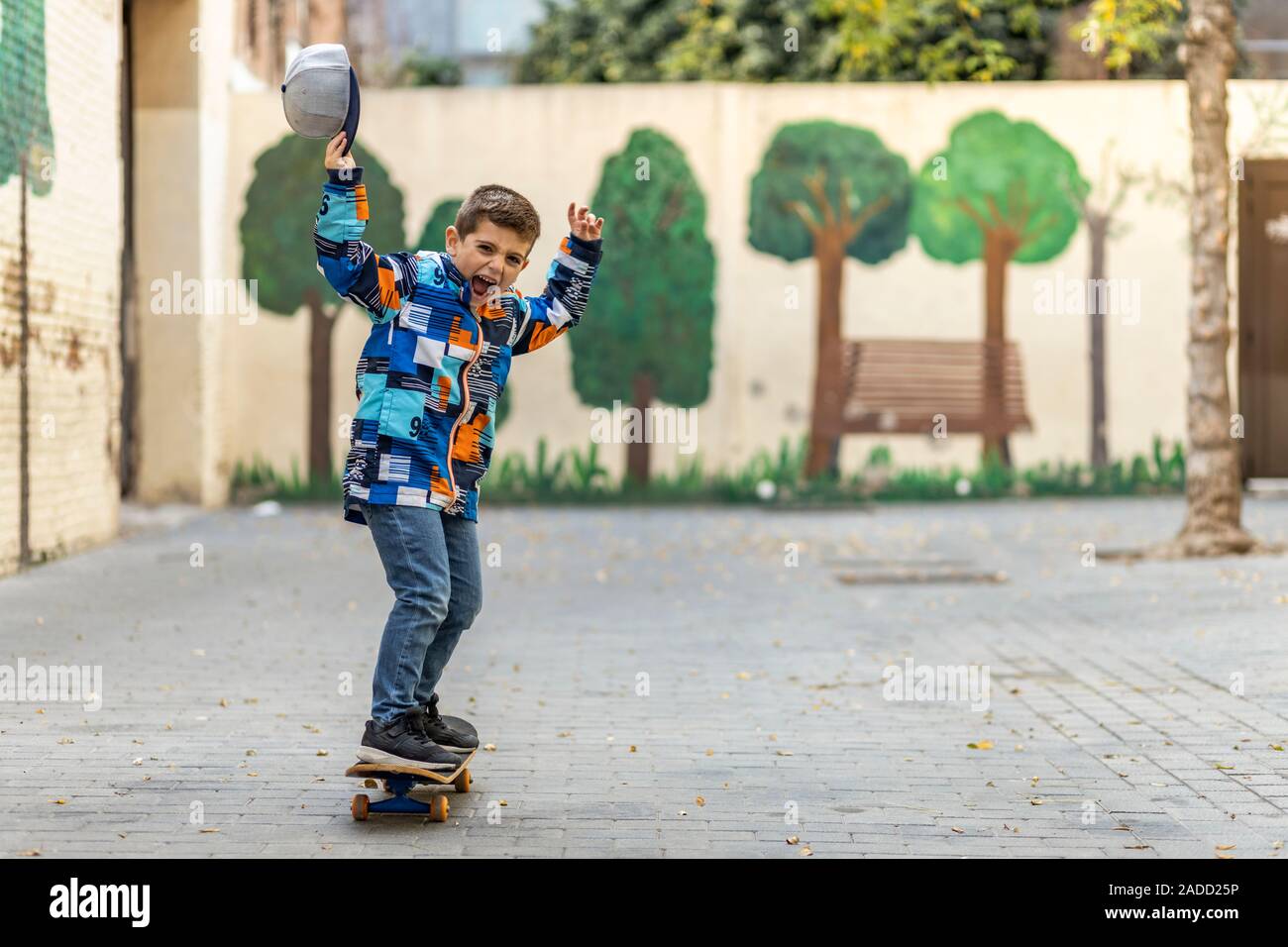 Euphoric little kid riding on his skateboard Stock Photo - Alamy