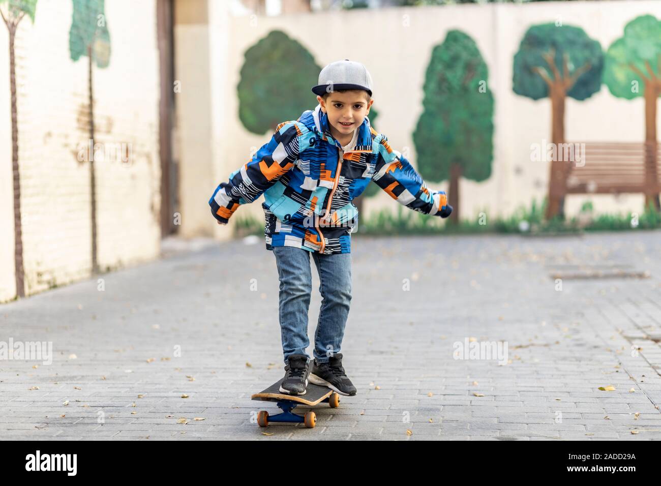 Euphoric little kid riding on his skateboard Stock Photo - Alamy