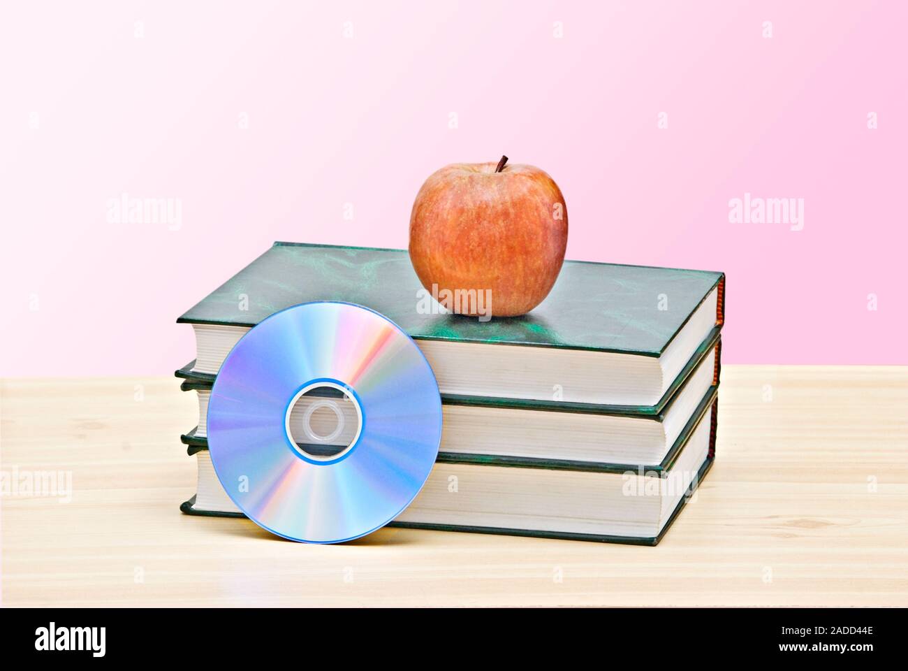 Apple, dvd, and books as a symbol of transition from old to new ways of learning Stock Photo