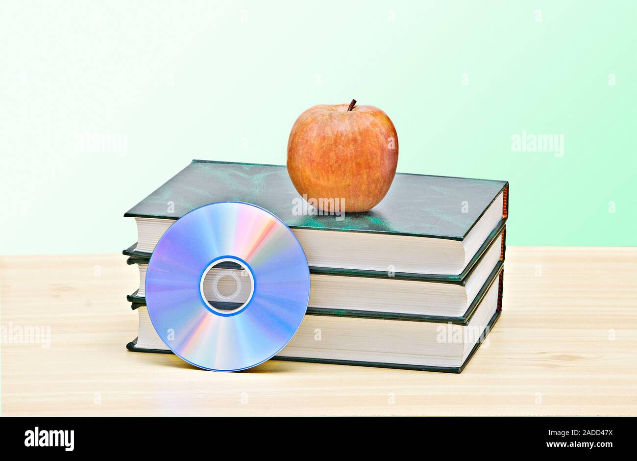 Apple, dvd, and books as a symbol of transition from old to new ways of learning Stock Photo