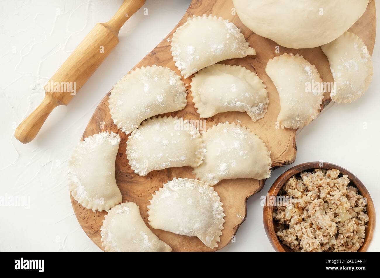 Cooking homemade dumplings with meat from raw homemade dough. National cuisine of Slavic peoples. Stock Photo
