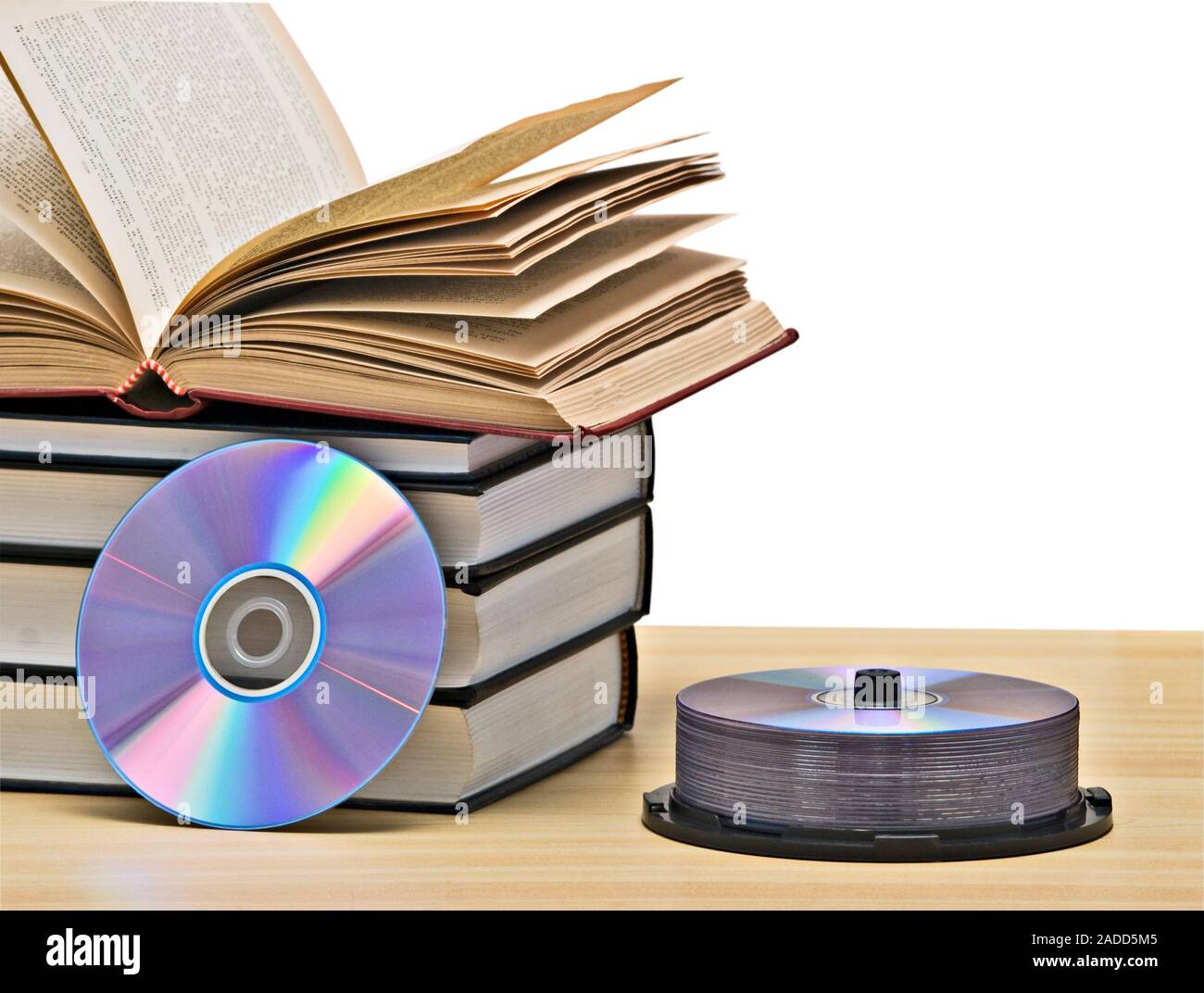 Pile of books  and DVD disk as symbols of old and new methods of information storage Stock Photo