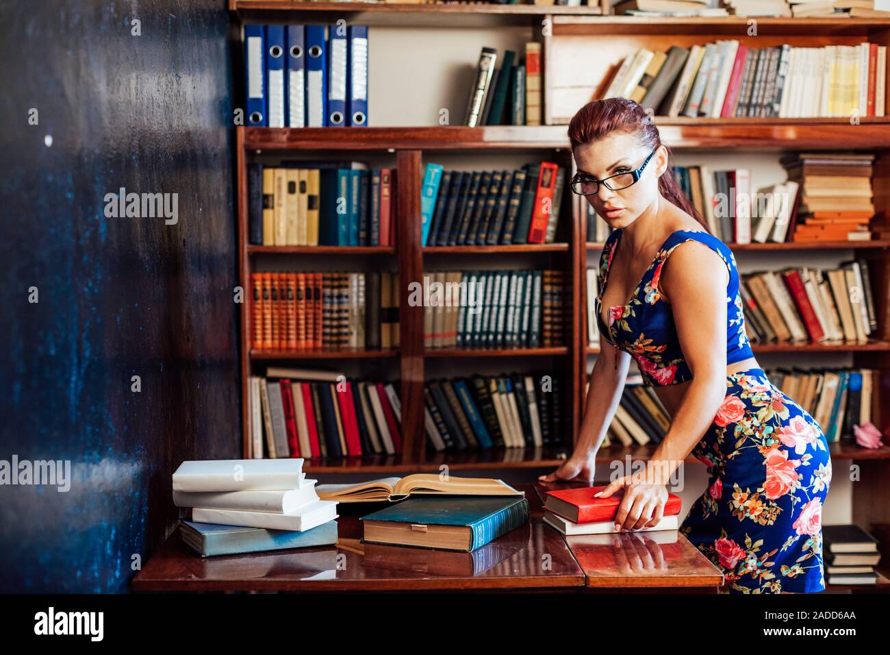 a woman sits at a desk book librarian education Stock Photo