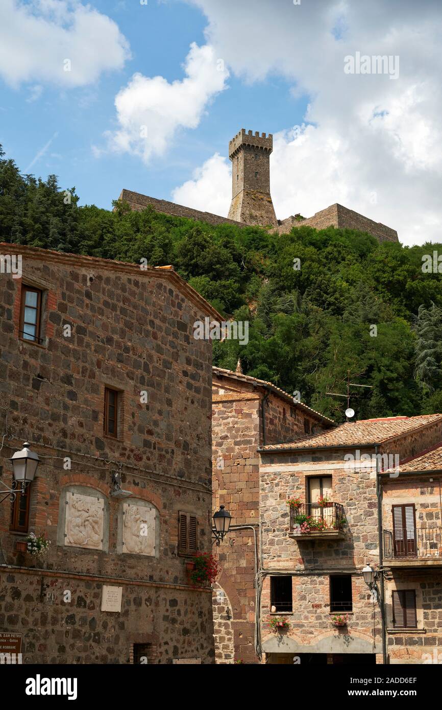 The Fortezza di Radicofani above the houses and architecture of the hilltop Tuscan town of Radicofani, Val d'Orcia,Tuscany Italy Europe Stock Photo