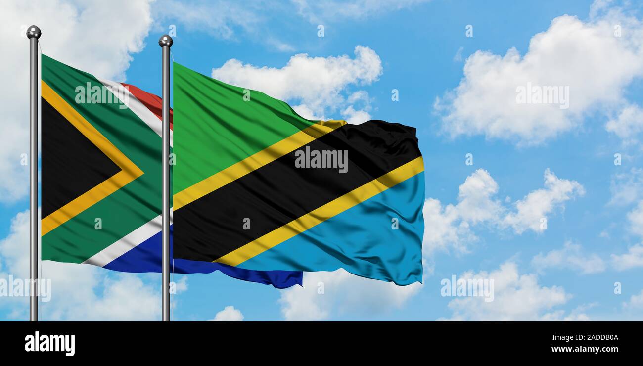 South Africa and Tanzania flag waving in the wind against white cloudy ...