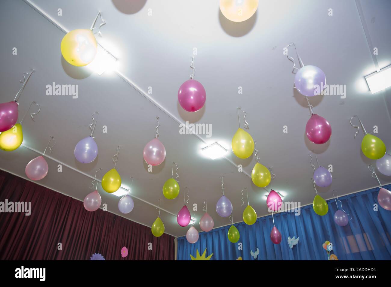 Pink And Yellow Balloons Float On The White Ceiling In The