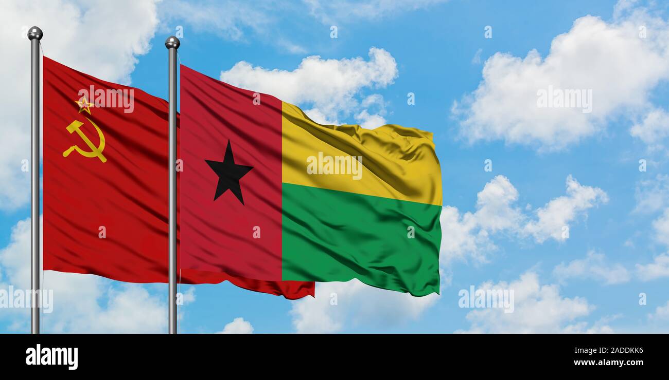 Soviet Union and Guinea Bissau flag waving in the wind against white cloudy blue sky together. Diplomacy concept, international relations. Stock Photo