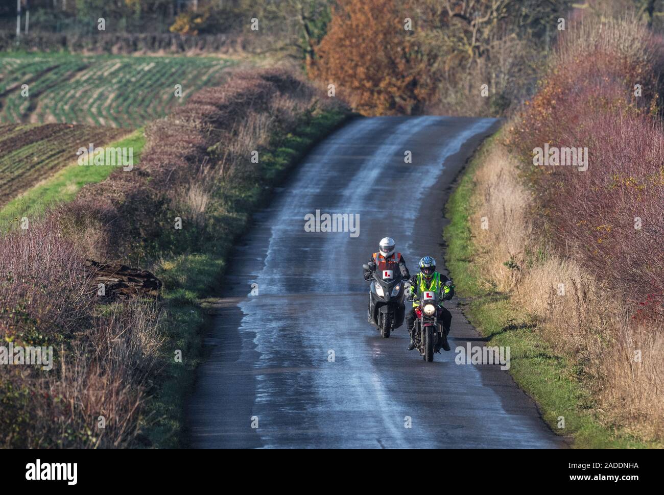 Learner motor cyclist with an instructor riding down a quite country lane. Stock Photo