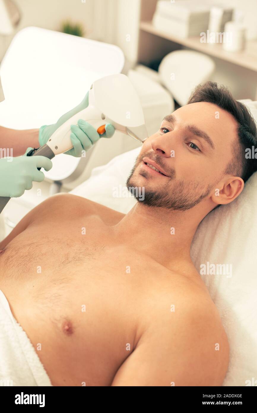 Bearded Man Smiling And Having Laser Hair Removal On His Face